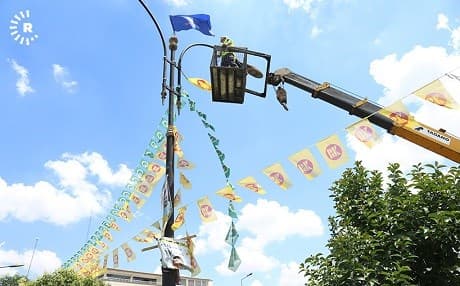 Municipal workers remove campaign materials from a streetlight in Erbil on Monday. Photo: Rudaw