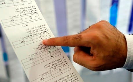 An Iraqi electoral commission employee examines electronic counting machine print-outs in the central holy city of Najaf on May 13, 2018. Photo: Haidar Hamdani / AFP