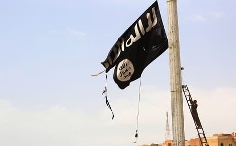 A member of the US-backed Syrian Democratic Forces (SDF) removes an ISIS flag in the town of Tabqa, April 30, 2017. File photo: Delili Souleiman / AFP