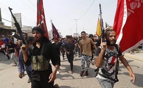 Armed Iraqi civilians attend the funeral of a protester allegedly killed by security forces on Monday night. Photo: Haidar Mohammed Ali / AFP 