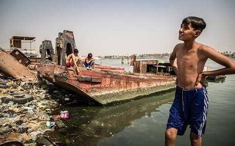 Children swim in the trash-strewn Shat al-Arab river in Basra. Photo: Tom Peyre-Costa/NRC