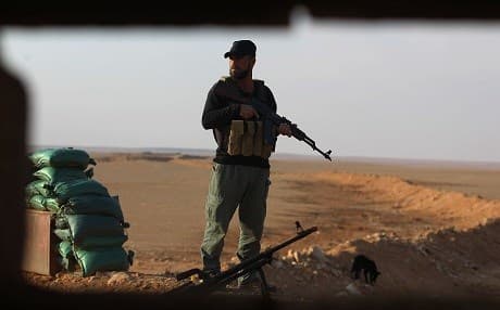An Iraqi Shiite fighter of the Hashd al-Shaabi paramilitary force stands guard at a border position in al-Qaim in Iraq's Anbar province, opposite Syria's Deir ez-Zor region on November 12, 2018. Iraqi troops have reinforced their positions along this porous frontier. Photo: Ahmad al-Rubaye/AFP