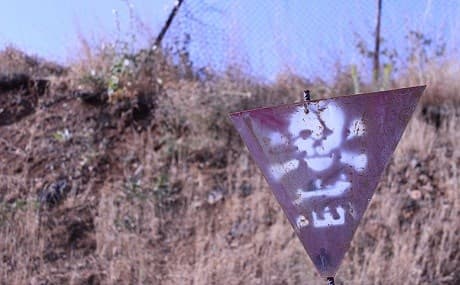 A sign warns of mines and other UXO from the Iran-Iraq War on a hillside in Penjwin, Sulaimani province. File photo: Robert Edwards / Rudaw 