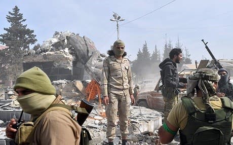 Members of Turkey-backed Syrian militias stand in front of the destroyed statue of Kawa the Blacksmith, a Kurdish cultural hero, in Afrin in March 2018. File photo: AFP