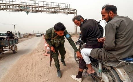 A member of the Raqqa Civil Council's security forces inspects motorcycle riders at a checkpoint in the former ISIS stronghold on October 16, 2018. File photo: Delil Souleiman | AFp