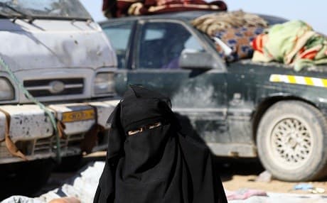 A woman who fled fighting between Syrian Democratic Forces and ISIS in the frontline Syrian village of Baghuz waits to be screened and registered by the SDF in Deir ez-Zor on February 3, 2019. File photo: Delil Souleiman | AFP