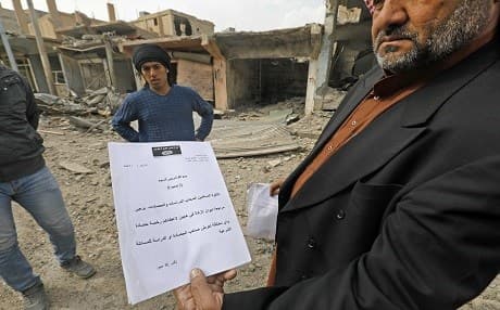 Ali Jaber, the mayor of the city of Hajin formerly an ISIS bastion, holds up jihadist documents on January 27, 2019. Photo: Delil Souleiman | AFP