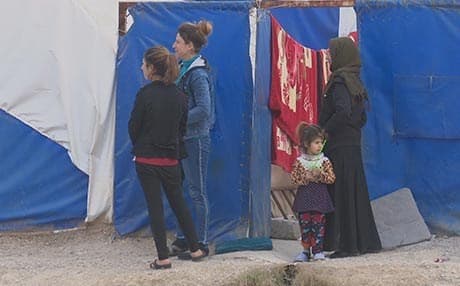 Iraqis displaced in a camp in Duhok Province gather outside of a building in a shelter. File photo: Rudaw