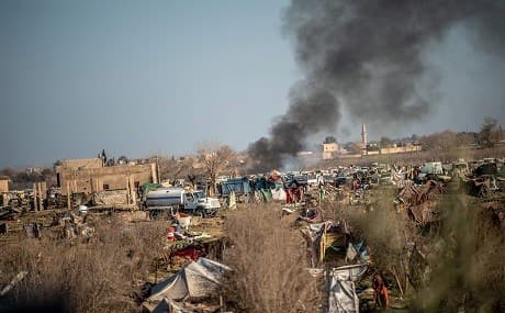 Smokes rises from a makeshift camp for ISIS members and their families in the town of Baghouz, eastern Syria, March 9, 2019. Photo: Bulent Kilic / AFP 