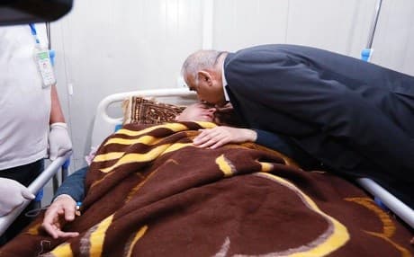 Iraqi PM Adil Abdul-Mahdi kisses the head of a man, who survived the Tigris ferry sinking, in a hospital in Mosul on March 21, 2019. Photo: Iraqi PMO handout/AFP