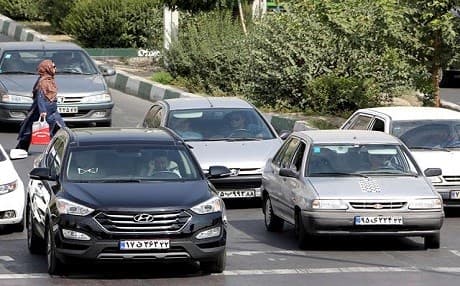 A picture taken on September 12, 2015 shows Iranians driving a Pride car manufactured by SAIPA group and a Hyundai ix45 luxury car in northern Tehran. Photo: Atta Kenare | AFP
