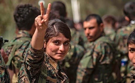 A female SDF fighter flashes the victory sign while celebrating the defeat of ISIS near the Omar oil field in eastern Syria, March 23, 2019. Photo: Delil Souleiman / AFP