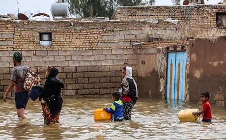 An Iranian family walks through a flooded street in a village around the city of Ahvaz, in Iran's Khuzestan province, March 31, 2019. Mehdi Pedramkhoo / Tasnim / AFP 