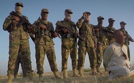 In this still taken from an Islamic State (ISIS) propaganda video published on messaging app Telegram on Sunday, April 14, 2019, a man identified as Mohammed Abdullah is shown kneeling before militants before he is executed. Photo: Islamic State media / Telegram 