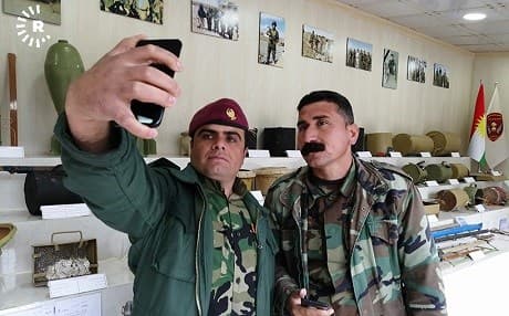 Peshmerga snap a selfie at a display of weapons and explosives seized in the war against Islamic State (ISIS). Photo: Hejar Jawhar/Rudaw 