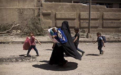 A woman checks on her children as they flee during fighting between Iraqi forces and ISIS militants, in Mosul, Iraq, on May 17, 2017. File photo: Maya Alleruzzo | AP