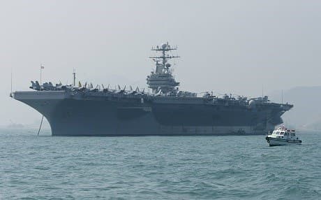 In this file photo taken on December 23, 2004, small boat sails by the USS Abraham Lincoln moored in Hong Kong. Photo Samantha Sin | AFP