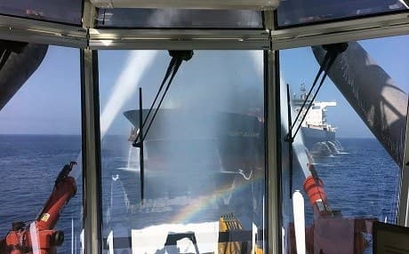 In this photo dated Thursday June 13, 2019, made available by the Norwegian shipowner Frontline, shows the oil tanker Front Altair through glass observation window as water cannon operate during the firefighting of the fire onboard the Norwegian ship in the Gulf of Oman. Photo: Frontline via AP