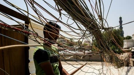 A man checks a knot of electric cables supplying homes in the Iraqi capital Baghdad on July 29, 2018 Photo: AFP/File