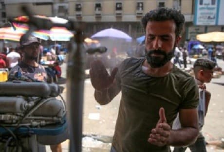 An Iraqi man uses a curbside shower to cool off during a heat wave in the capital Baghdad on June 14, 2019. Photo: AFP/ Ahmad al-Rubaye