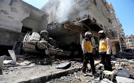 Members of the Syrian Civil Defence (White Helmets) gather at the site of a reported air strike on the town of Ariha, in the south of Syria's Idlib province on July 28, 2019.  Photo: Omar Haj Kadour | AFP 