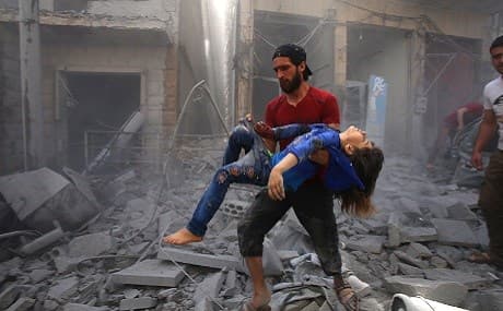 A man evacuates a young bombing casualty after a reported air strike by regime forces and their allies in the jihadist-held Syrian town of Maaret Al-Noman in the southern Idlib province, May 26, 2019. File photo: Abdulaziz Ketaz / AFP 