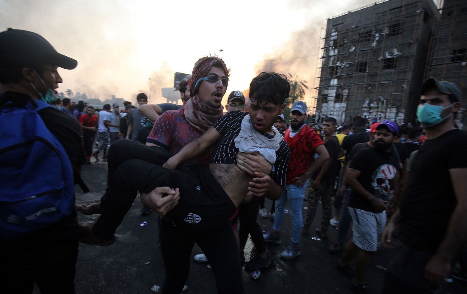 An Iraqi protester carries a wounded comrade during a demonstration against state corruption, failing public services and unemployment in Baghdad, October 2, 2019. Photo: Ahmad al-Rubaye / AFP 