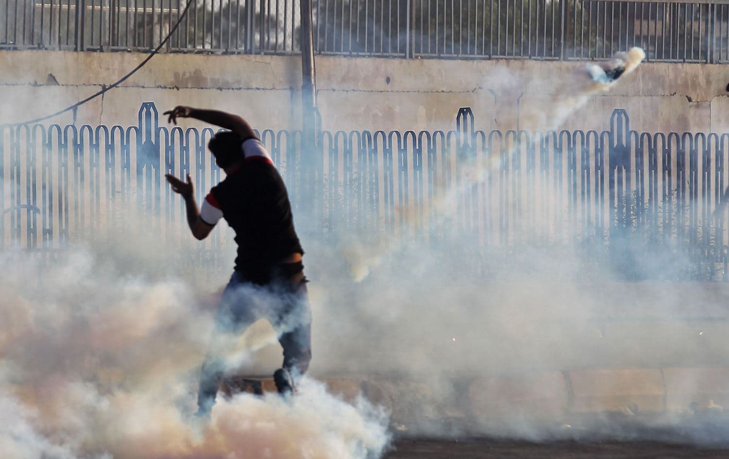 A protester gestures amid smoke from burning tyres and tear gas during a demonstration in the Iraqi capital Baghdad, October 5, 2019. Photo: Ahmad al-Rubaye / AFP