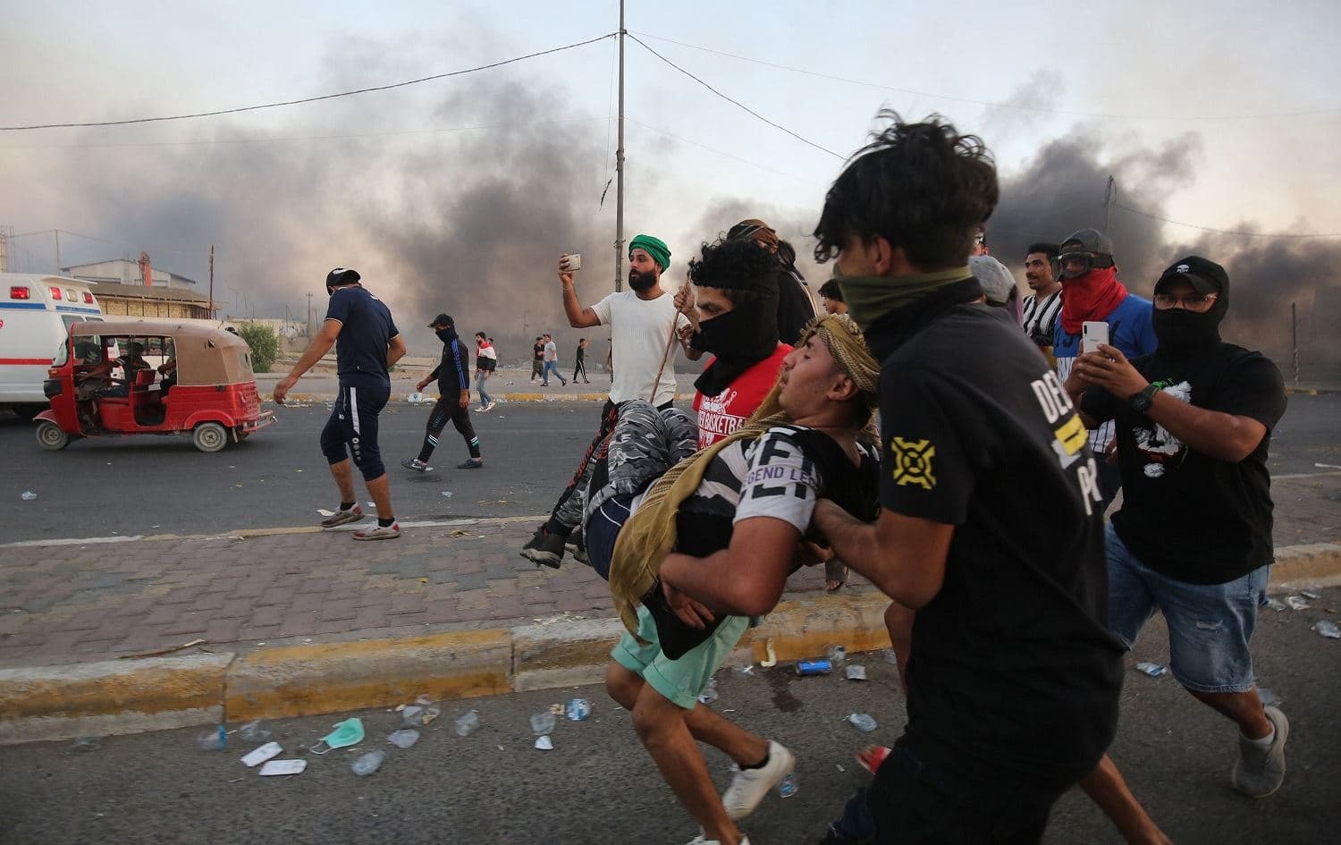 Iraqi protesters evacuate a wounded comrade during clashes with security forces in the Iraqi capital Baghdad, October 5, 2019. Photo: Ahmad al-Rubaye / AFP