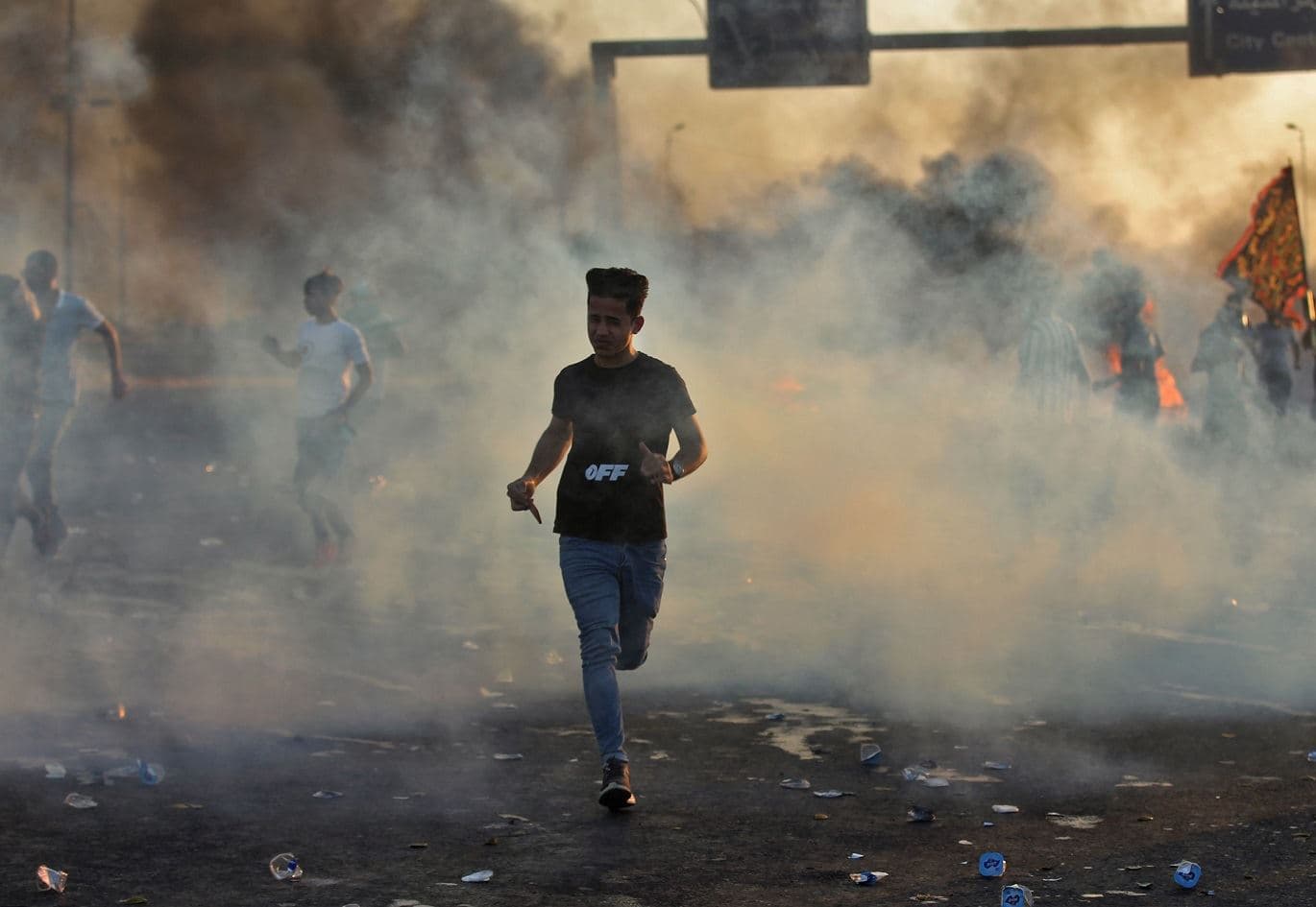 Iraqi demonstrators run amidst smoke from burning tyres during a demonstration in Baghdad on October 5, 2019. Photo: AFP / Ahmad Al-Rubaye