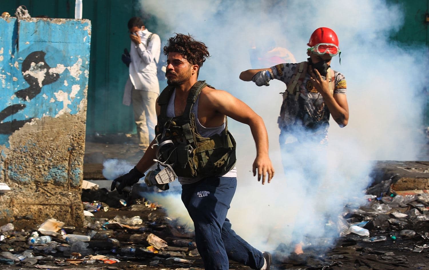 Iraqi protesters run from tear gas during clashes with security forces at Baghdad's al-Khalani Square during ongoing anti-government demonstrations on November 15, 2019. Photo: AFP / Ahmad al-Rubaye