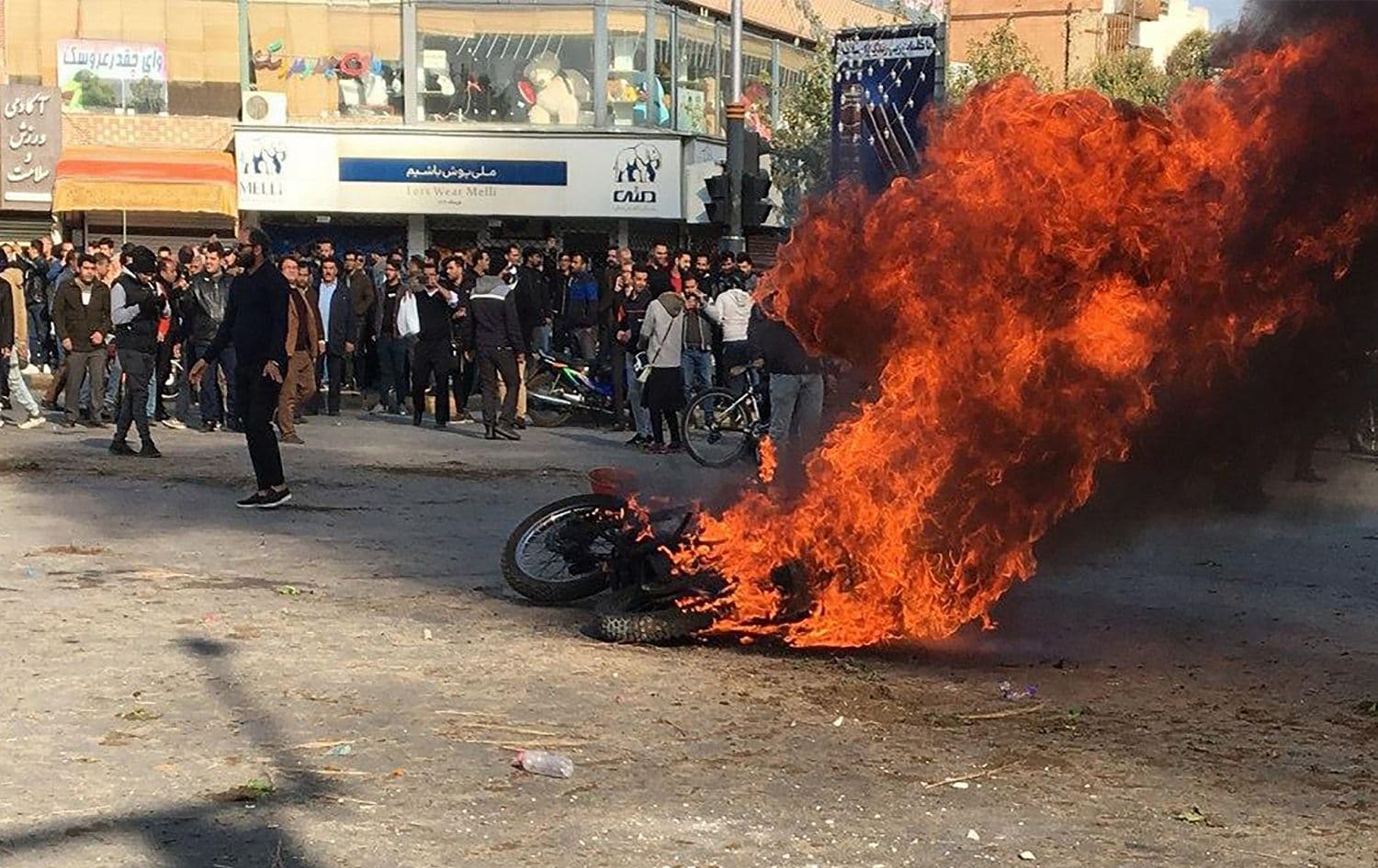 Iranian protesters gather around a burning motorcycle during a demonstration against an increase in gasoline prices in the central city of Isfahan, November 16, 2019. Photo: AFP 