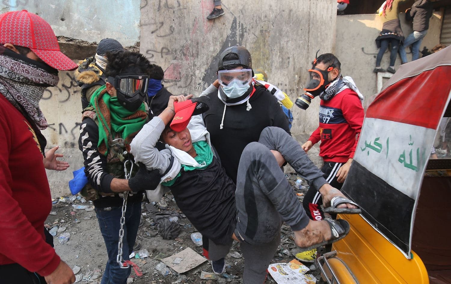 Iraqi demonstrators help an injured youth during clashes with security forces in the capital Baghdad, November 26, 2019. Photo: Ahmad al-Rubaye / AFP