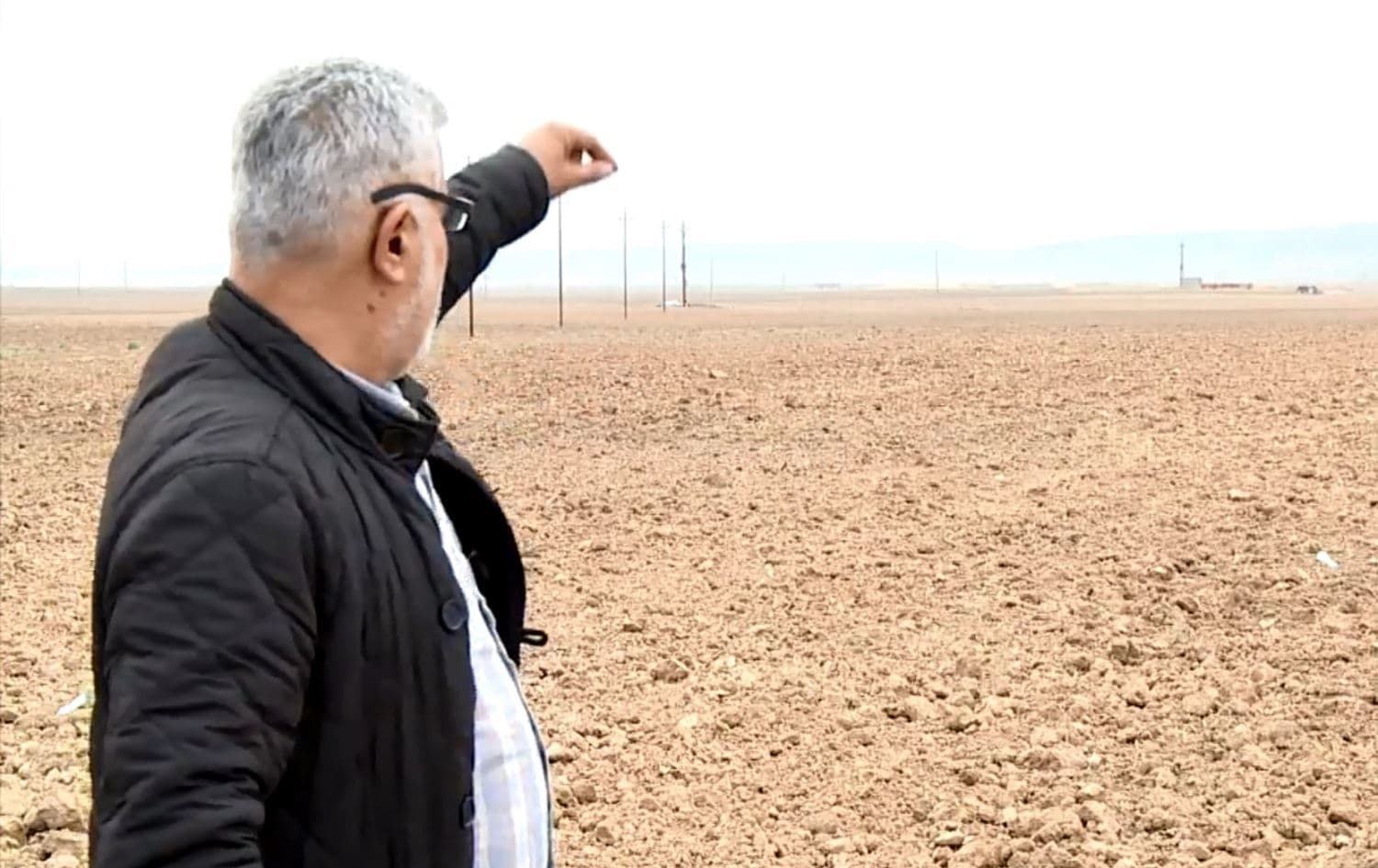 Kurdish farmer Dashti Agha watches his land being plowed by Arab settlers. Photo: Rudaw TV