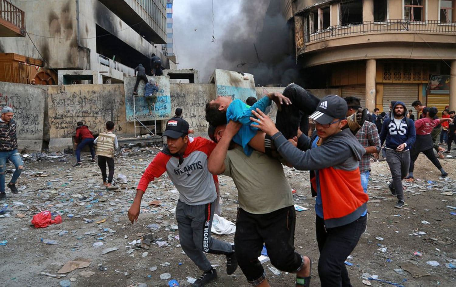 A wounded protester is carried to receive first aid during clashes with security forces on Rasheed Street in Baghdad, Iraq, November 28, 2019. Photo: Khalid Mohammed / AP
