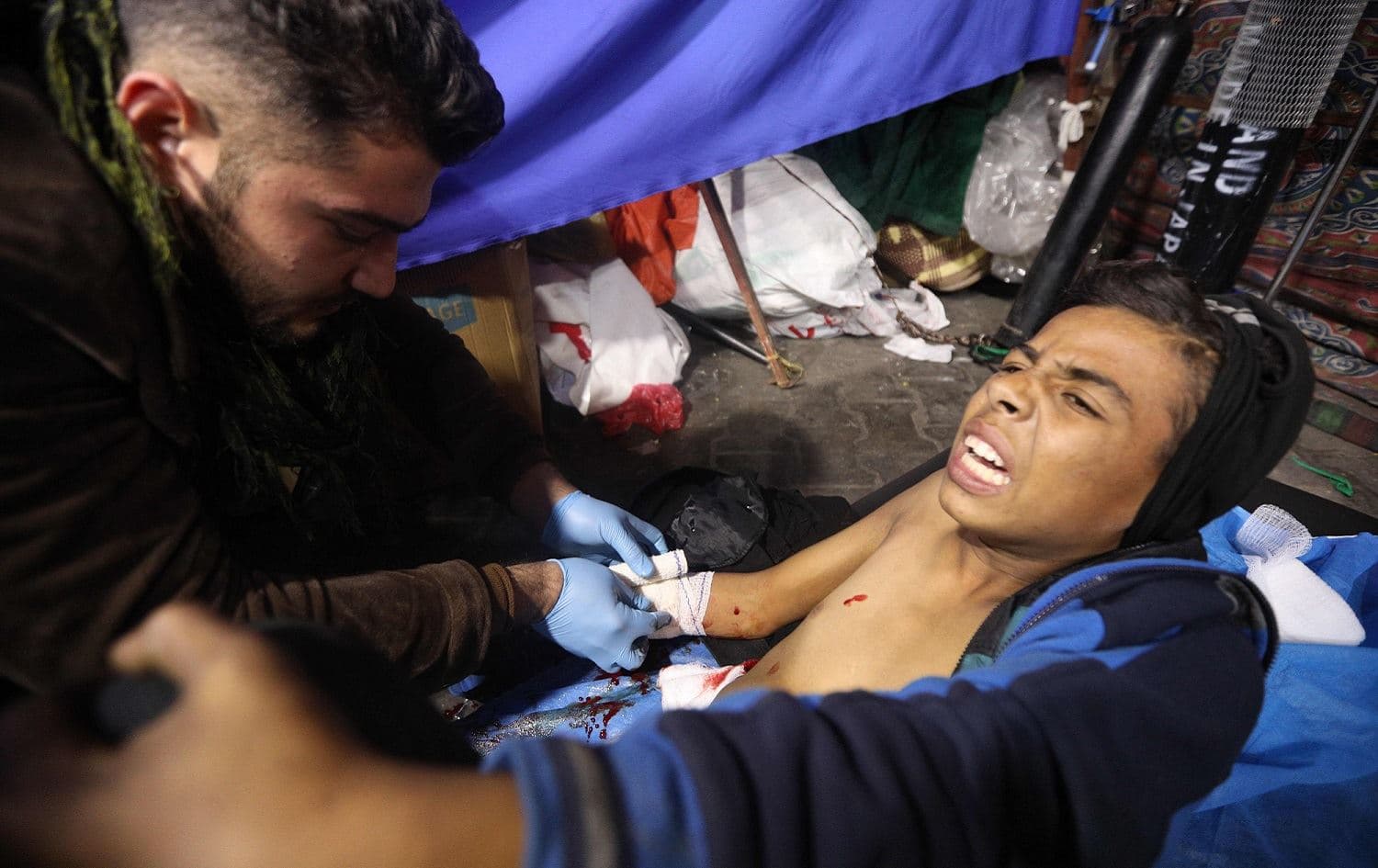 A wounded protester is treated at a mobile clinic in Tahrir Square after unidentified men attacked an anti-government protest camp in Baghdad late on December 6, 2019. Photo: Stringer / AFP