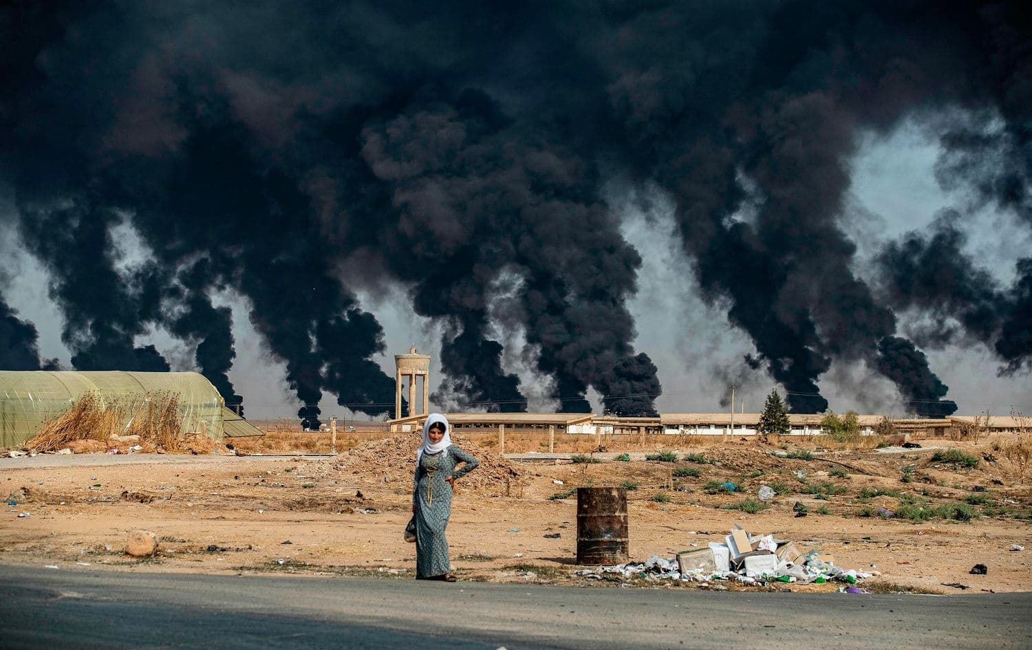 A woman stands along the side of a road on the outskirts on Tel Tamr on October 16, 2019. Photo: Delil Souleiman/AFP