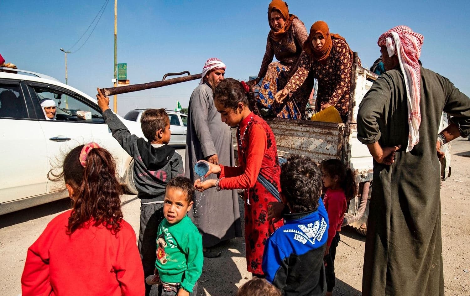 Civilians arrive in northwestern Syria's Hasakeh province on October 10 after fleeing the Turkish bombing on towns along theTurkish border. Photo: Delil Souleiman/AFP