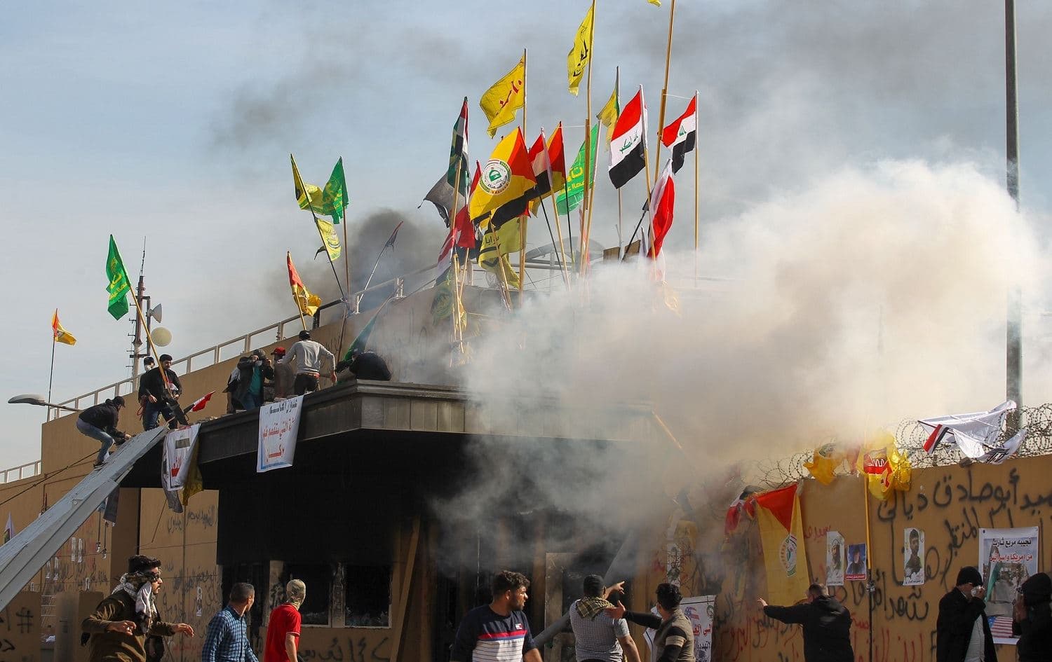 US forces (unseen) fire teargas canisters at supporters and members of the Hashed al-Shaabi paramilitary force at the US Embassy in Baghdad on January 1, 2020. Photo: Ahmed al-Rubaye/AFP