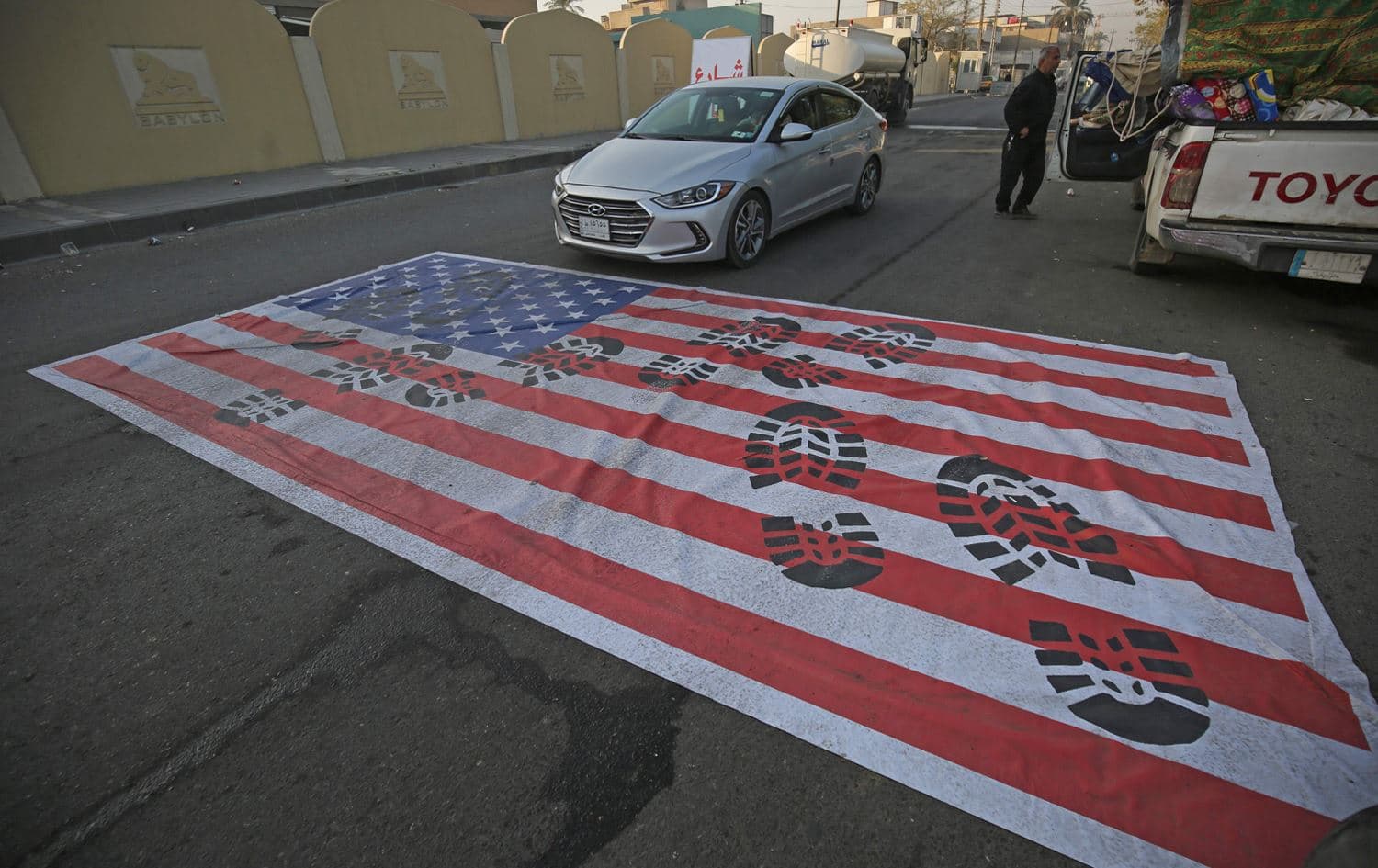 A mock US flag is laid on the ground for cars to drive on in the Iraqi capital Baghdad on January 3, 2020. Photo: Ahmed al-Rubaye/AFP