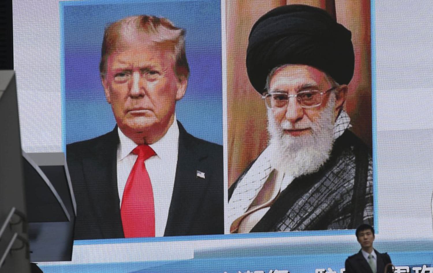 A man walks by a huge screen showing U.S. President Donald Trump, left, and Iranian Supreme Leader Ayatollah Ali Khamenei, in Tokyo, Wednesday, Jan. 8, 2020. Photo: AP/Koji Sasahara