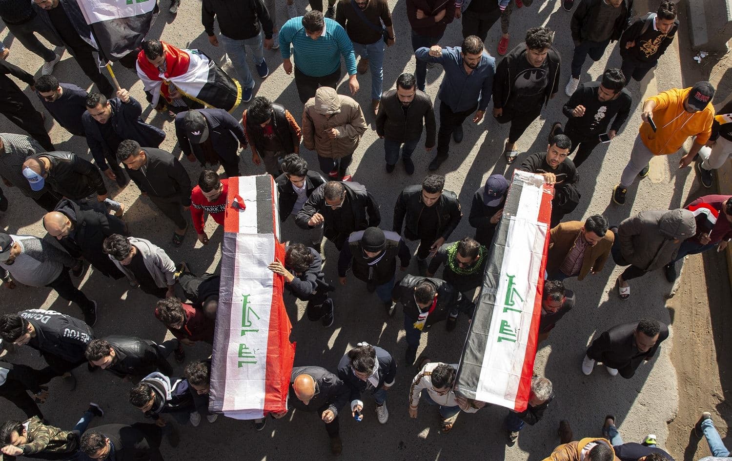 Iraqis in Basra carry mock coffins as they take part in a rally on January 11, 2020, to mourn Ahmad Abdul Samad, a correspondent for Dijla TV , and his cameraman Safaa al-Ghali, shot dead in the city on Friday. Photo: Hussein Faleh / AFP 