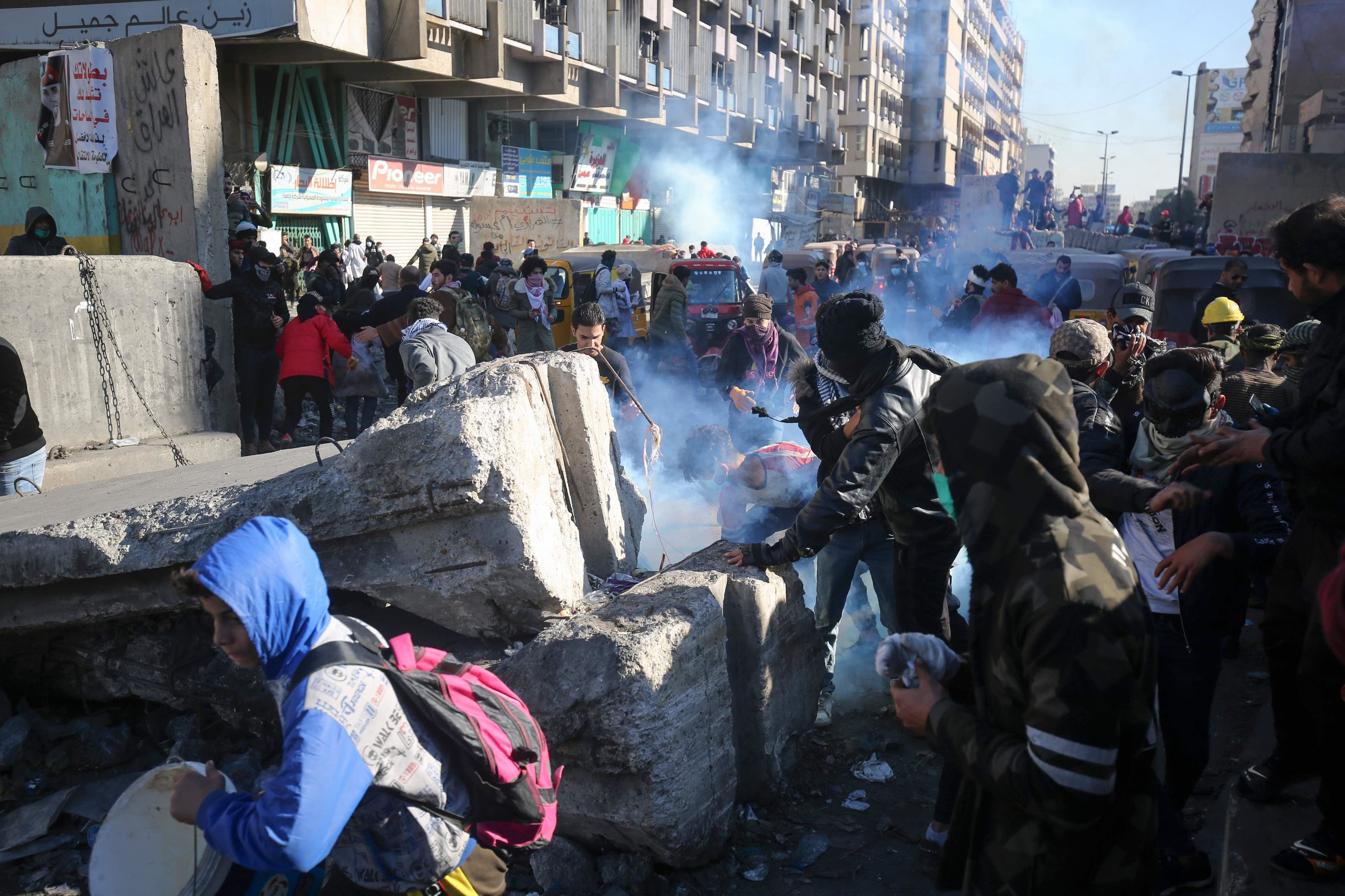 Iraqi protesters duck to avoid tear gas canisters amid clashes with security forces during an anti-government demonstration in al-Khilani Square in Baghdad on January 26, 2020. Photo: Ahmad al-Rubaye / AFP