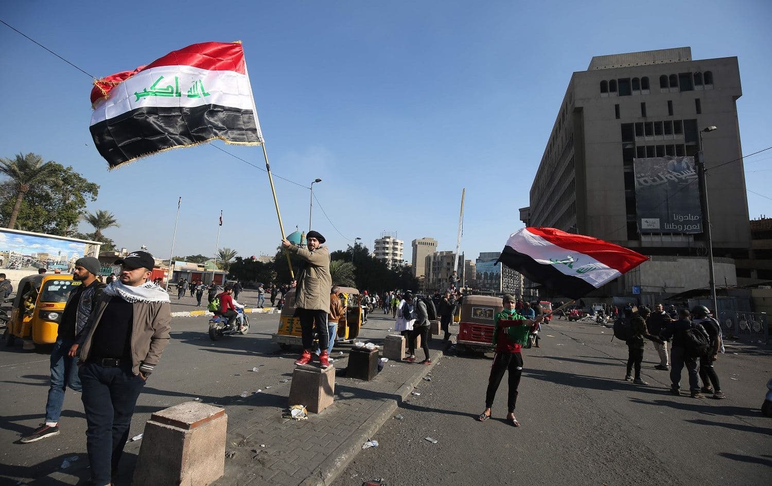 Iraqi demonstrators wave national flags during ongoing anti-government protests in Baghdad's Al Wathba square, on January 31, 2020. Photo: Ahmad al-Rubaye/AFP