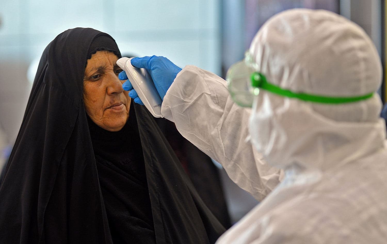The body temperature of an Iraqi woman returning from Iran is measured upon her arrival at Najaf International Airport, February 21, 2020. Photo: Haidar Hamdani / AFP 