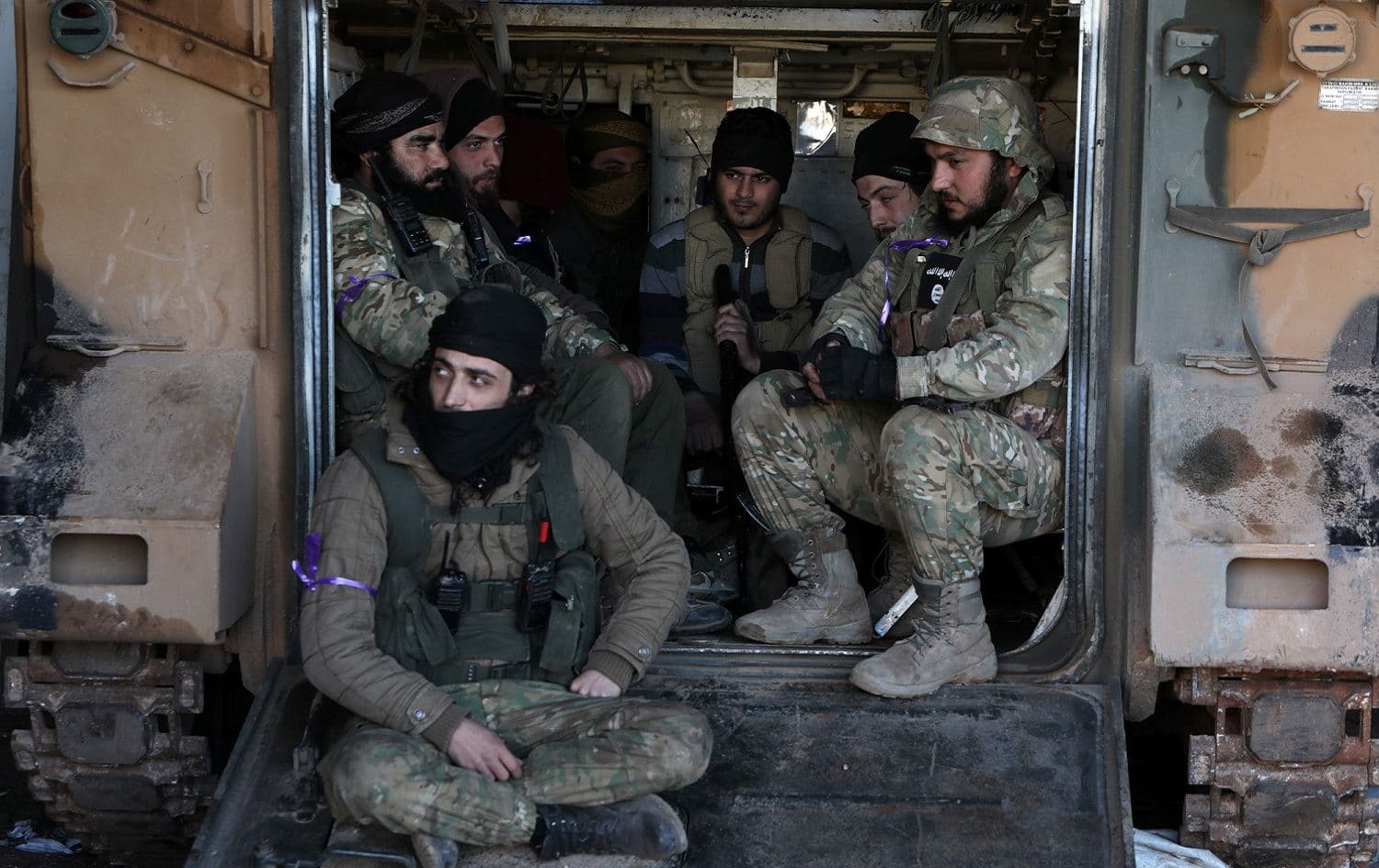 Turkish-backed Syrian fighters gather in the back of an armoured personnel carrier at a position in Afis on the outskirts of the regime-controlled town of Saraqeb, east of the Idlib province in northwestern Syria, February 26, 2020. Photo: Bakr al-Kasem / AFP