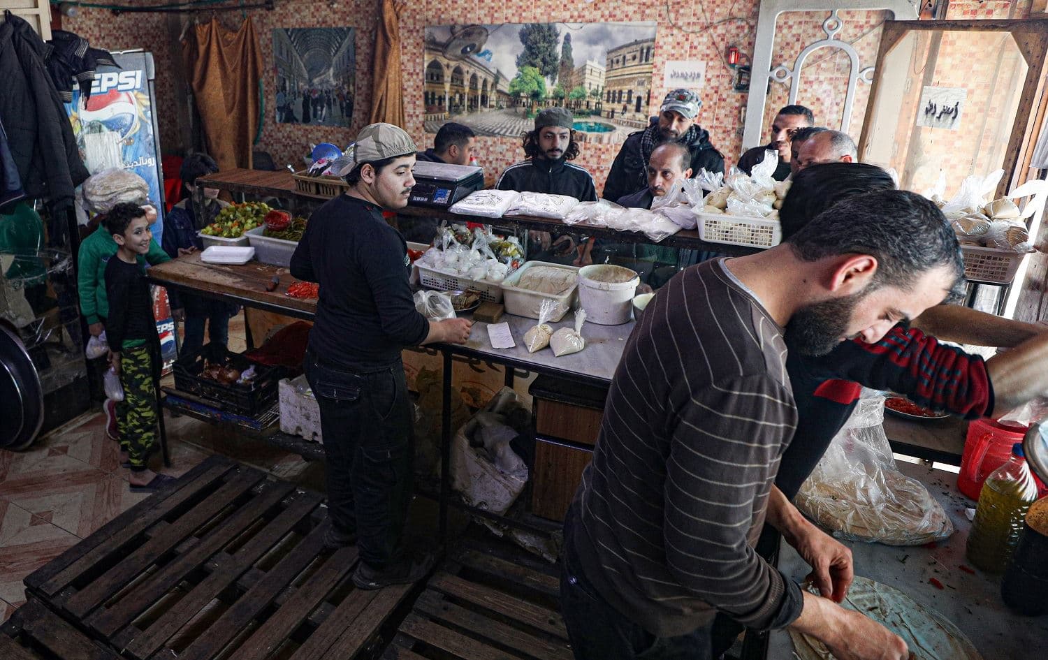 Residents buy sandwiches at a shop in the relative calm of Idlib, northwest Syria on March 6, 2020. Photo: Omar Haj Kadour / AFP