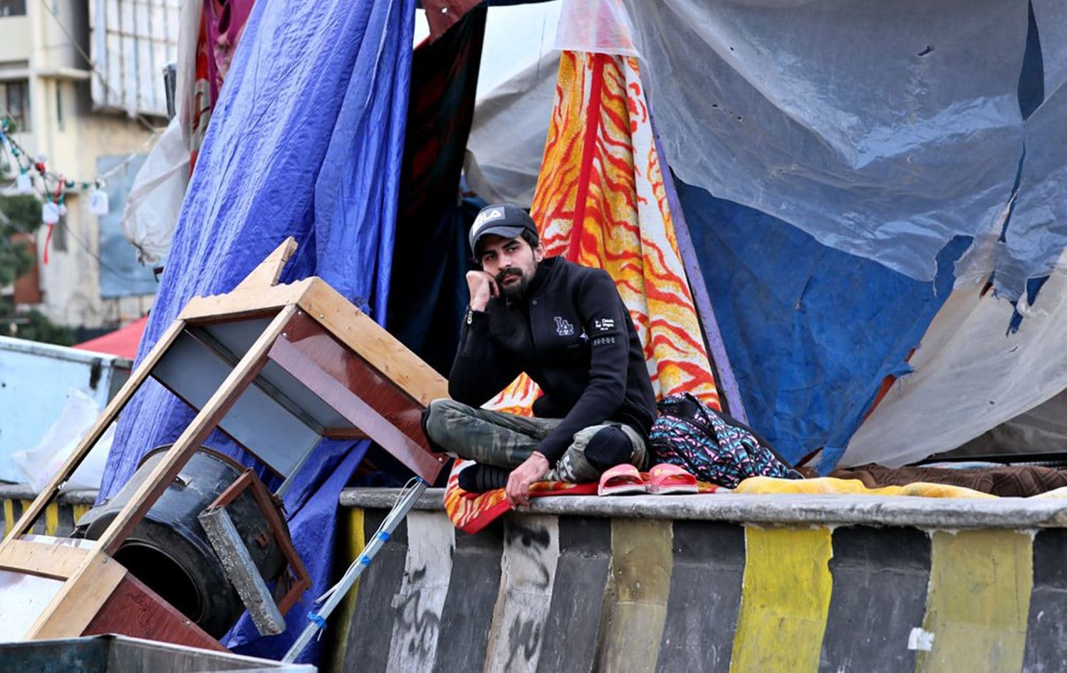 A protester sits outside his tent in Baghdad, Iraq, March 7, 2020. Photo: Hadi Mizban / AP