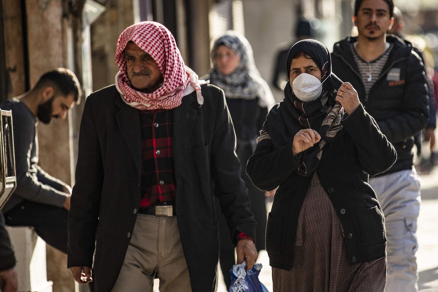  A woman wearing a protective mask, due to fears of COVID-19 coronavirus spread, walks along a market street in Qamishli in Syria's northeastern Hasakah province on March 22, 2020. Photo: Delil Souleiman/AFP
