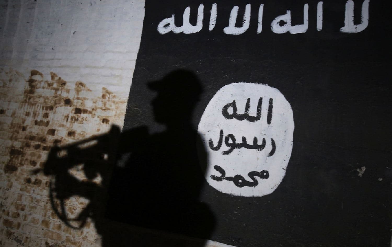 A member of the Iraqi Security Forces (ISF) walks past a mural bearing the Islamic State (ISIS) logo in Albu Sayf, southern Mosul. File photo: AFP 